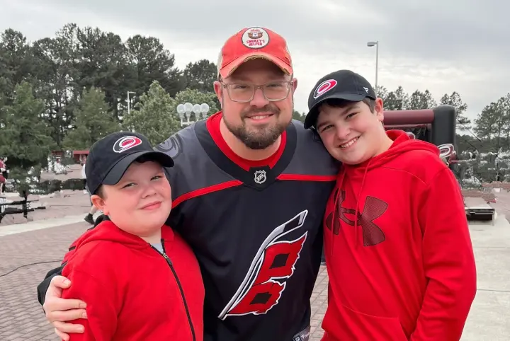 Mike with his two sons at a hockey game